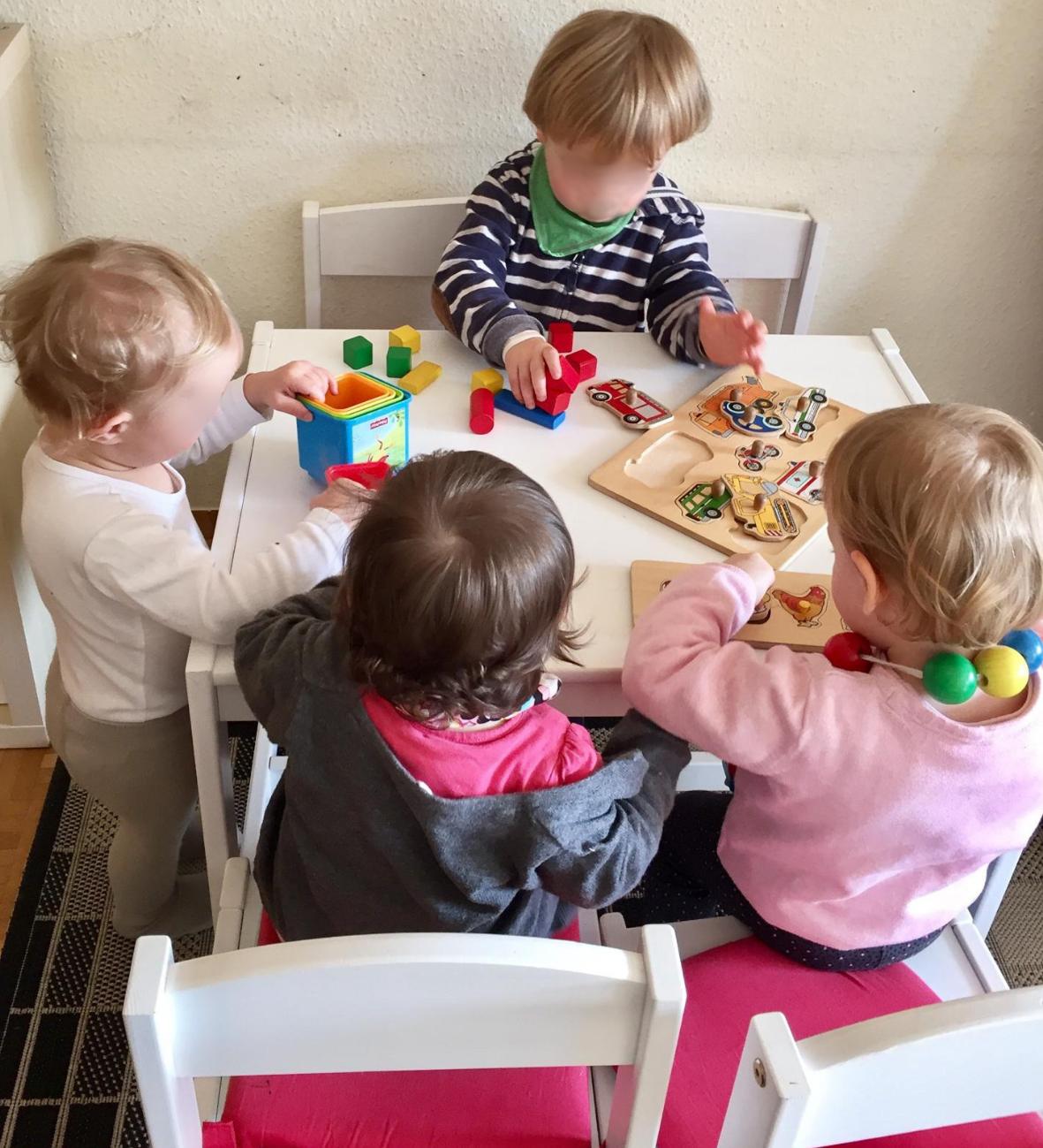 Kinder malen mit bunten Farben am Tisch