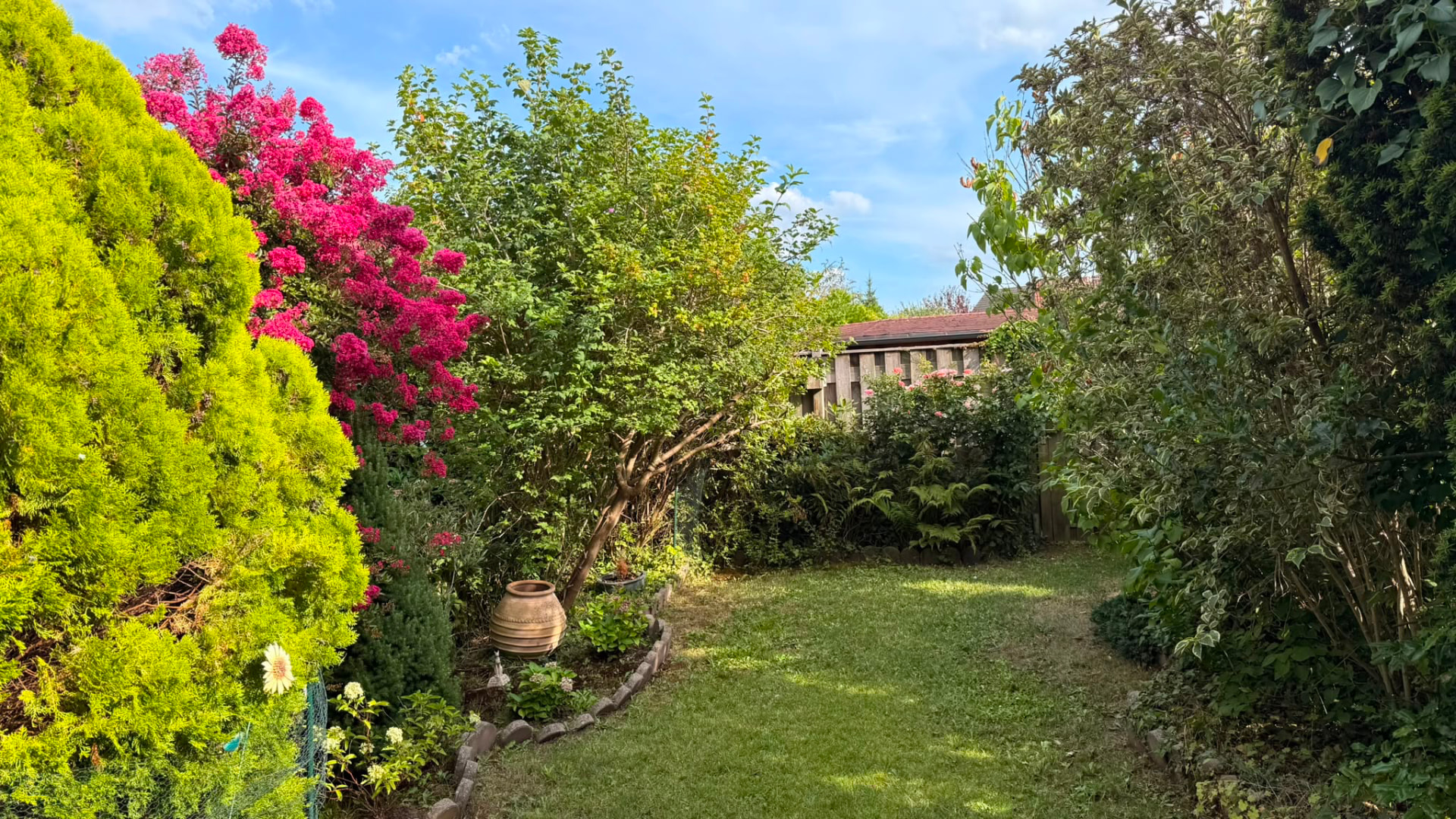 Grüner Garten mit Rasen, Blumen und Spielplatz