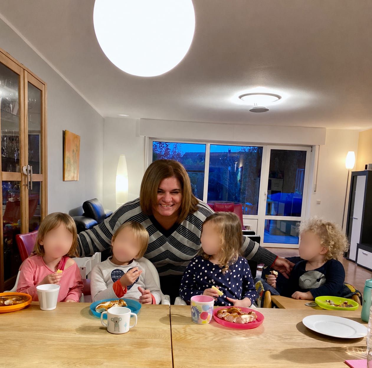 Adriana mit Kindern beim gemeinsamen Essen in der Kindertagespflege
